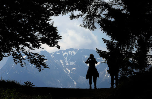A hiker photographs the panoramic view of the German alps near Pfronten. The German Alps had fewer visitors at the start of this year than before the coronavirus pandemic. Photo: picture alliance / Karl-Josef Hildenbrand/dpa
