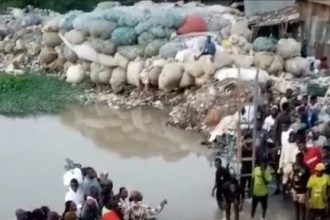 The state of River Denro, a channel linking the Ogun River: Residents helping one another to cross the high water current to avoid being swept away