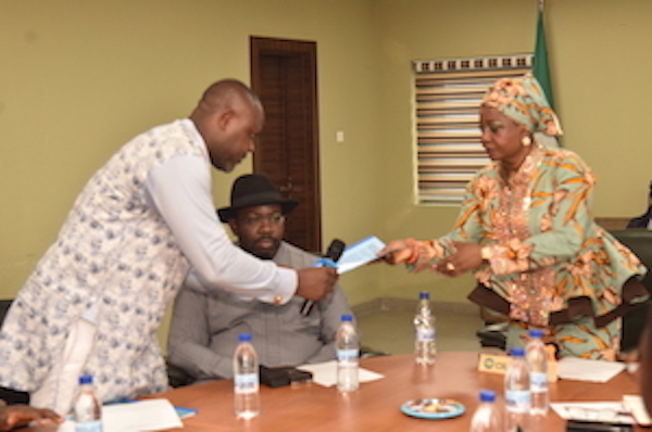 The Chairman of the NDDC Governing Board, Mrs. Lauretta Onochie, (right) Receiving documents from the President of Ogoni Youth Peace Movement, Comrade Nulai Tombari, (left) during a courtesy visit at the NDDC headquarters. In the middle is the Representative of the North West on the NDDC Board, Prince Sule Sani Sami.