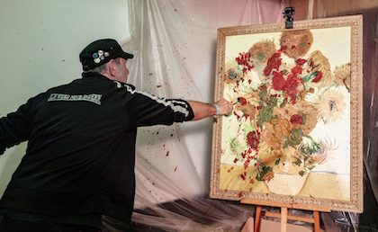 22 April 2023, Hamburg: TV chef Ole Plogstedt throws mash at a painting in the St. Pauli Museum. Under the motto "Fire away with mashed potatoes," museum visitors are allowed to throw a mashed potato of containerized food at a framed reprint of Vincent van Gogh's painting "Fifteen Sunflowers" and discuss the goals and means of the "Last Generation" as well as how the media and the public deal with it. Photo: Markus Scholz/dpa