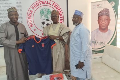 Lulu (middle) presenting a FOSLA shirt to Gusau (left) with Sanusi on the right